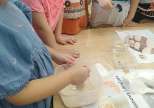 Dziewczynka sprawdza zaczyn drożdżowy.