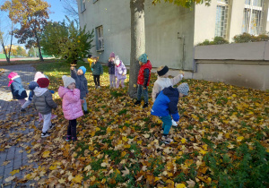 Dzieci bawią się w liściach.