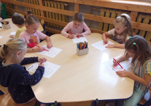 Dzieci z grupy „Odkrywcy” podczas wykonywania pracy plastycznej z symbolem Polski walczącej.