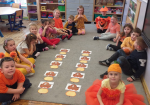 Zdjęcie przedstawia dzieci po przyporządkowaniu dyń do odpowiedniej liczby.