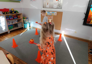 Dziewczynka i chłopiec z grupy „Misie” podczas rywalizacji w „dyniowych zawodach sportowych”.