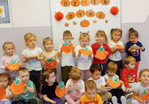 Zdjęci z dziećmi z grupy Biedronki prezentujące dynie wykonane z papierowych talerzyków.