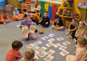 Dziewczynka dobiera pasujące do siebie dynie.