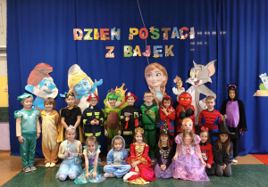Dzieci z grupy Motylki pozują do zdjęcia grupowego w strojach bajkowych.