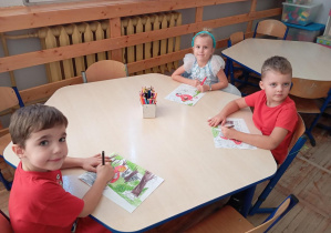 Na zdjęciu widzimy dzieci z grupy Odkrywcy podczas wykonywania pracy plastycznej o tematyce baśniowej.