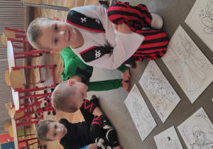 Chłopiec kuca przy wybranej przez siebie bajkowej kolorowance.