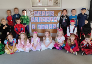 Chłopiec siedzący przy stoliku koloruje ilustracją bajkowego zamku.