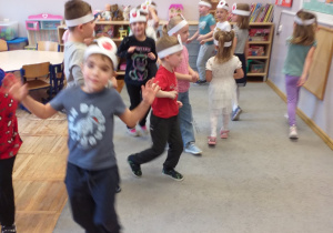 Zdjęcie przedstawia dzieci bawiące się w jedną z zabaw ruchowych z emblematami owoców i warzyw.