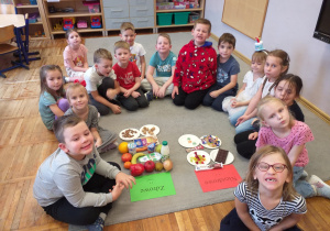 Zdjęcie przedstawia dzieci przed segregowaniem produktów zdrowych i niezdrowych.