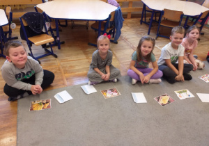 Zdjęcie przedstawia dzieci układające małe obrazki z puzzli.