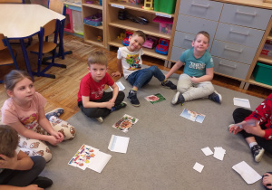 Zdjęcie przedstawia dzieci układające małe obrazki z puzzli.