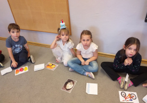 Zdjęcie przedstawia dzieci układające małe obrazki z puzzli.