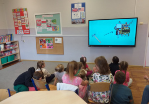 Zdjęcie przedstawia dzieci oglądające film edukacyjny o wynalazkach.