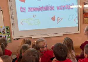 Dzieci oglądają na tablicy multimedialnej filmy dotyczące praw dziecka.