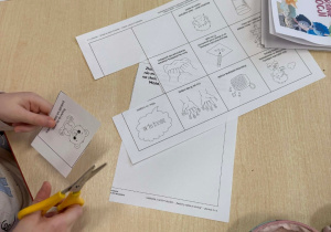 Dzieci wykonują karty pracy, które wkleją do swoich albumów.