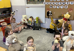 Dzieci prezentują swoje pluszowe misie przyniesione z domu.