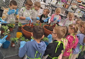 Dzieci sadzą kwiatki.