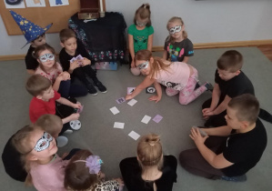 Dzieci z grupy Odkrywcy grają w grę pamięciową „Memory” o tematyce związanej z Andrzejkami.