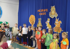 Zdjęcie przedstawia dzieci i dziewczynkę odgrywającą rolę miesiąca listopada.