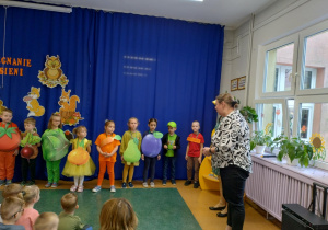 Zdjęcie przedstawia panią wicedyrektor chwalącą dzieci i gratulującą im udanego występu.