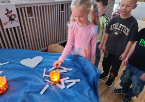 Dziewczynka z grupy „Misie” losuje karteczkę z wróżbą na temat swojej przyszłości.