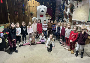 Dzieci z grupy Żabki pozują do zdjęcia z białym misiem.