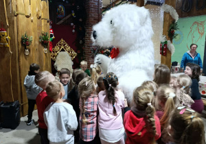 Dzieci przytulają się do Niedźwiedzia Polarnego.