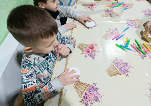 Chłopcy z grupy „Misie” tworzą własną bombkę na choinkę.