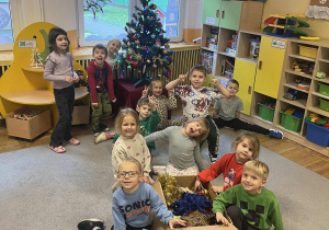 Dzieci pozują do zdjęcia z ozdobami świątecznymi.