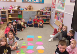 Zdjęcie przedstawia dzieci poznające inne rodzaje figur geometrycznych.