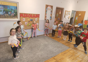 Dzieci pozują do zdjęcia z długim łańcuchem