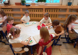 Na zdjęciu widzimy dzieci podczas nakładania farb.