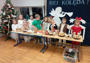 Zdjęcie przedstawia dzieci próbujące świątecznych wypieków.