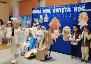 Dziewczynka przebrana za aniołka mówi swoją role.