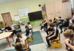 Dzieci uczą się matematyki poprzez zabawe z krzesełkami.