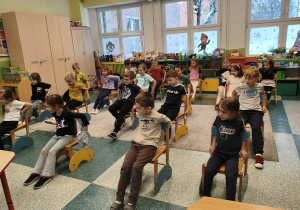 Dzieci uczą się matematyki poprzez zabawe z krzesełkami.