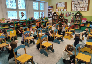 Dzieci uczą się matematyki poprzez zabawe z krzesełkami.