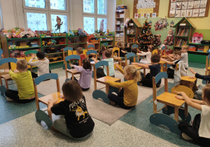 Dzieci uczą się matematyki poprzez zabawe z krzesełkami.