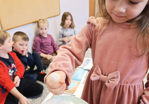 Dziewczynka sprawdza co dzieje się ze śniegiem gdy jest ciepło.
