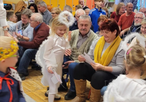 Dzieci z grupy Żabki podczas wręczania kolorowych laurek swoim babciom i dziadkom.