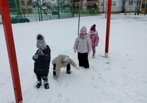 Dzieci stoją na tle bramki.