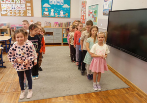 Dzieci z grupy Odkrywcy biorą udział w zawodach drużynowych pt. kto najszybciej pokona trasę z popcornem na łyżce.