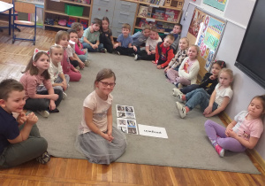 Zdjęcie przedstawia dzieci pozujące do zdjęcia z ilustracjami pingwinów.