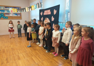 Zdjęcie przedstawia dziecko recytujące wierszyk.