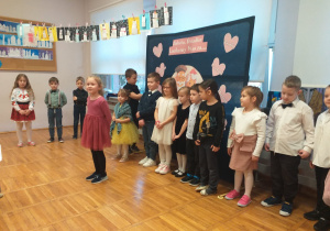 Zdjęcie przedstawia dziecko recytujące wierszyk.