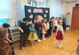 Zdjęcie przedstawia dziecko recytujące wierszyk.