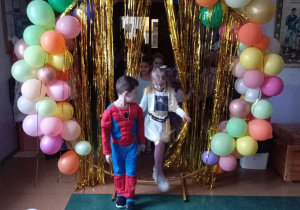 Dzieci z Grupy Odkrywcy przechodzą przez „Złotą Bramę” na Bal Karnawałowy.