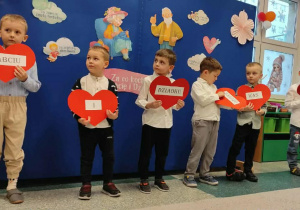 Chłopcy z grupy „Misie” trzymający serca z napisem –„ Babciu i Dziadku bardzo Was kochamy”