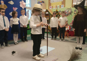 Chłopiec trzyma w ręku mikrofon w przebraniu dziadka.