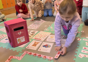 Dziewczynka układa walentynkowe domino.